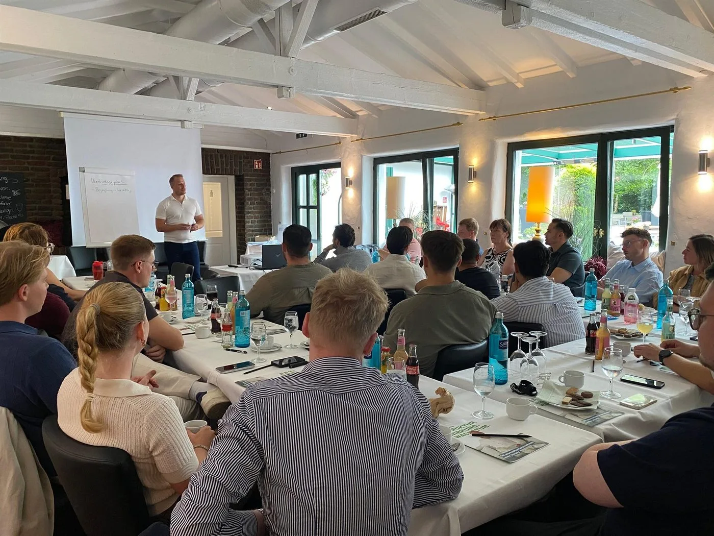 Jan Keiter am Flipchart mit der Struktur eines Vertriebsgesprächs, davor die Teilnehmer eines Workshops